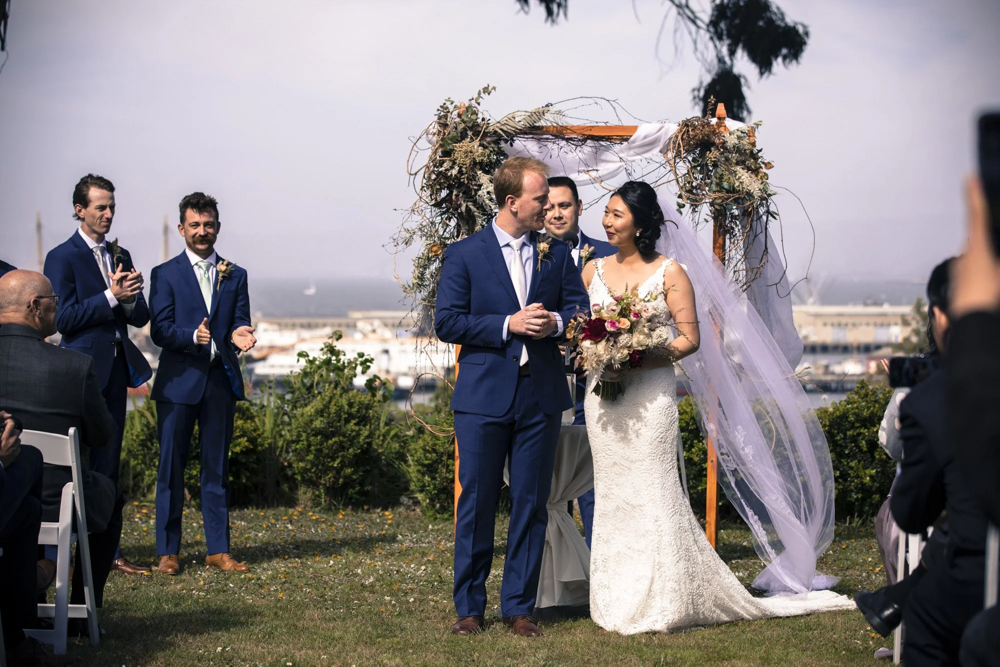 Bride and groom facing each other during their outdoor ceremony.
