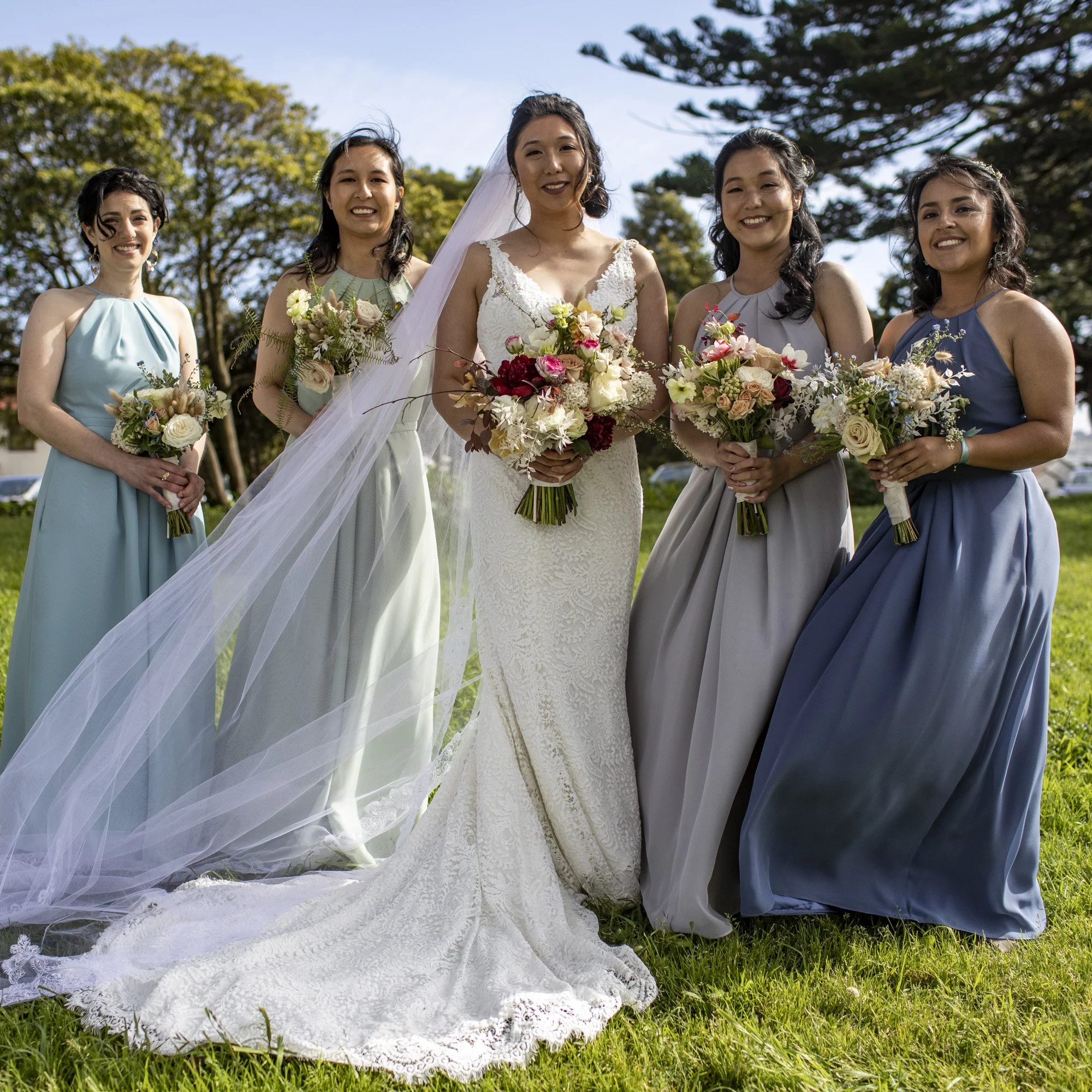 Bride standing with her bridesmaids outdoors after the ceremony.
