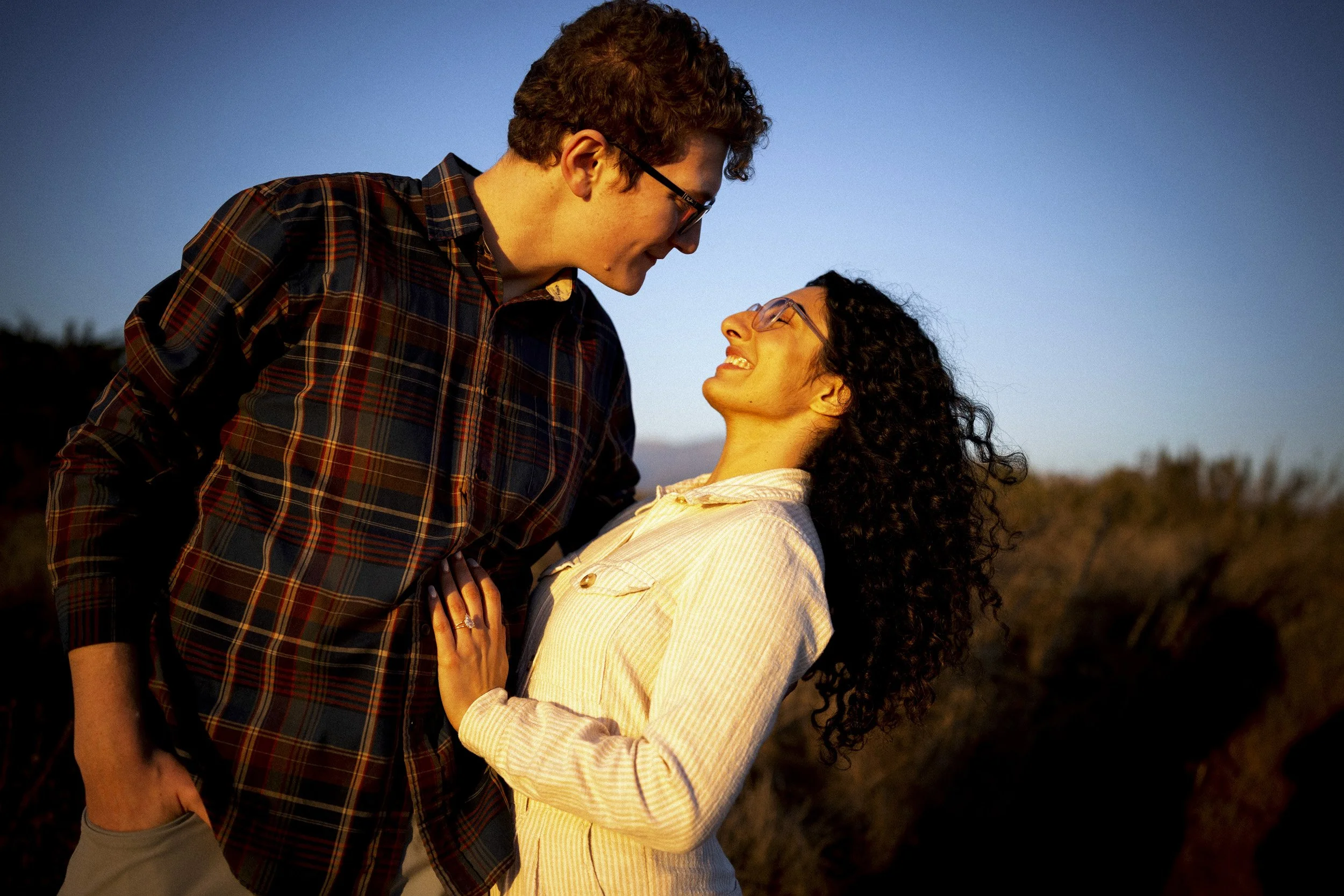 Couple smiling at each other on the Santa Barbara coastal bluffs.