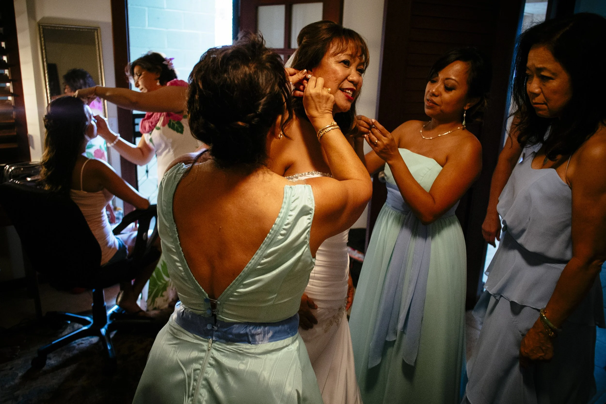 Bride surrounded by friends during joyful wedding preparations.