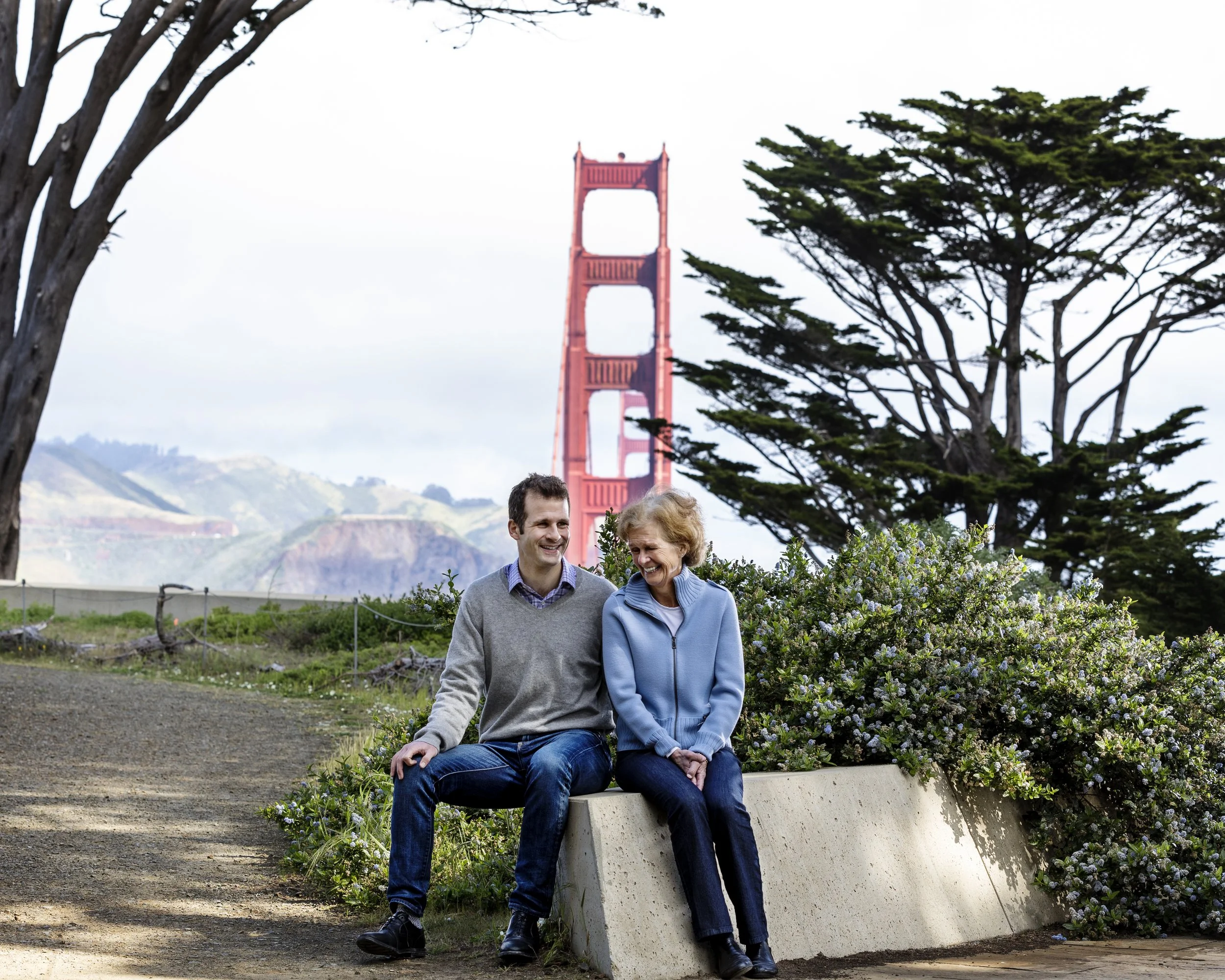 Mother and son seated together near a Golden Gate Bridge overlook.