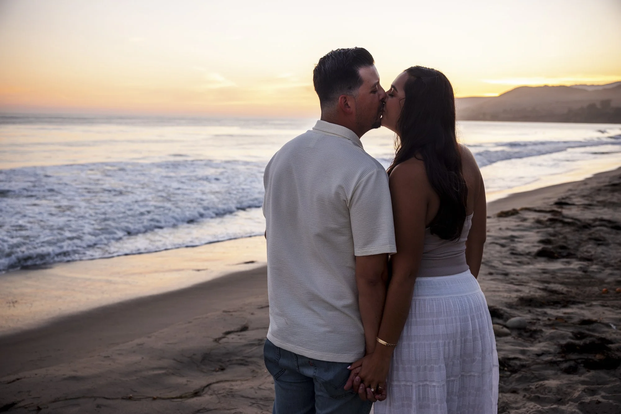 Newly engaged couple photographed in a pose they chose during their coastal portrait session