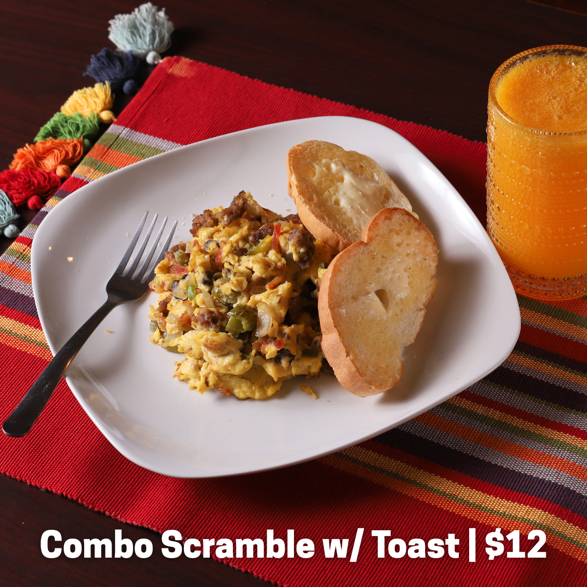 Scrambled eggs with meat and veggies, served with toast.