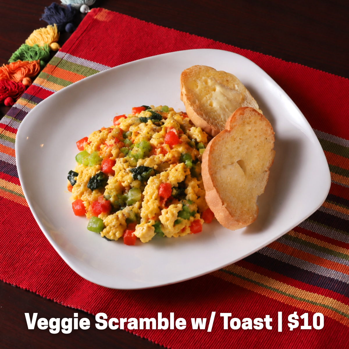 Scrambled eggs with mushrooms, onions, and peppers, served with toast.