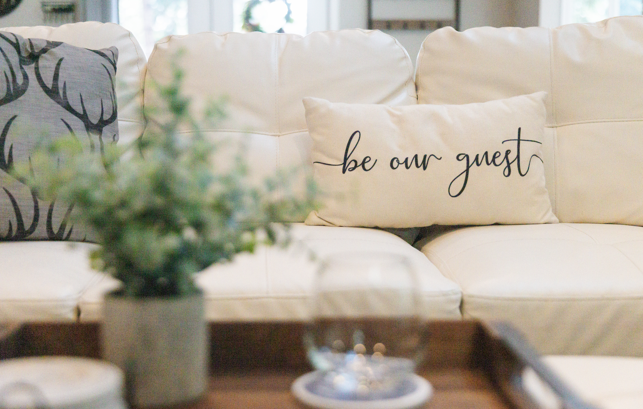cozy couch with be our guest pillow