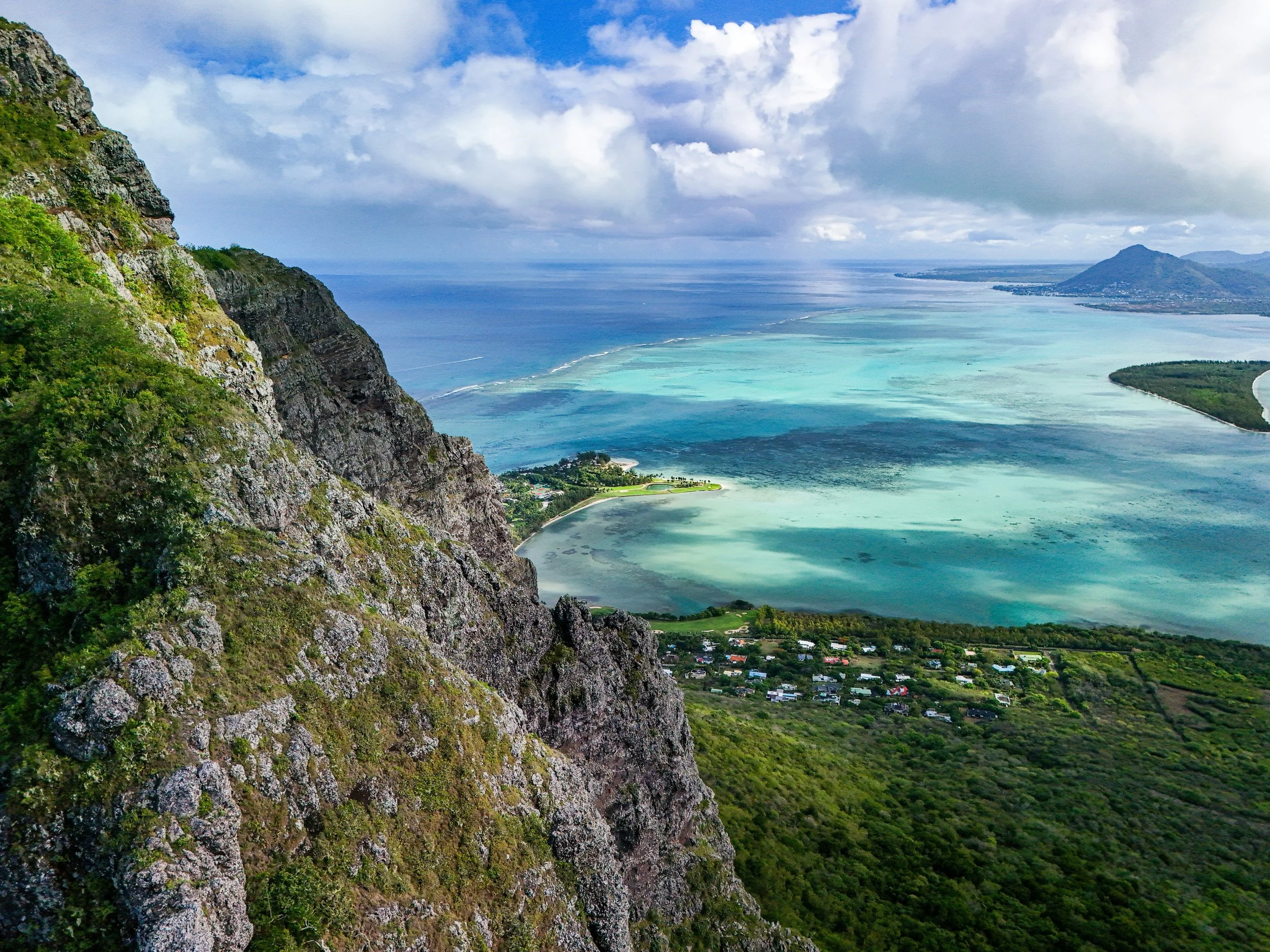 A view from altitude, looking out over the coastal town and waters of Mauritius.