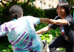 Two participants smiling and practicing a gentle supported lean.