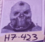 Close-up of a person wearing a skeleton mask with their hands near their face, labeled with the code H7-423.