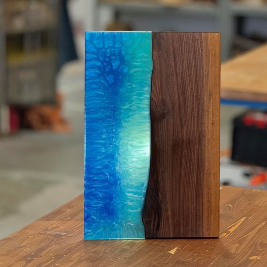 Handmade epoxy resin and wood serving board with natural grain and vibrant blue resin accents, ideal for cheese, charcuterie, or entertaining.