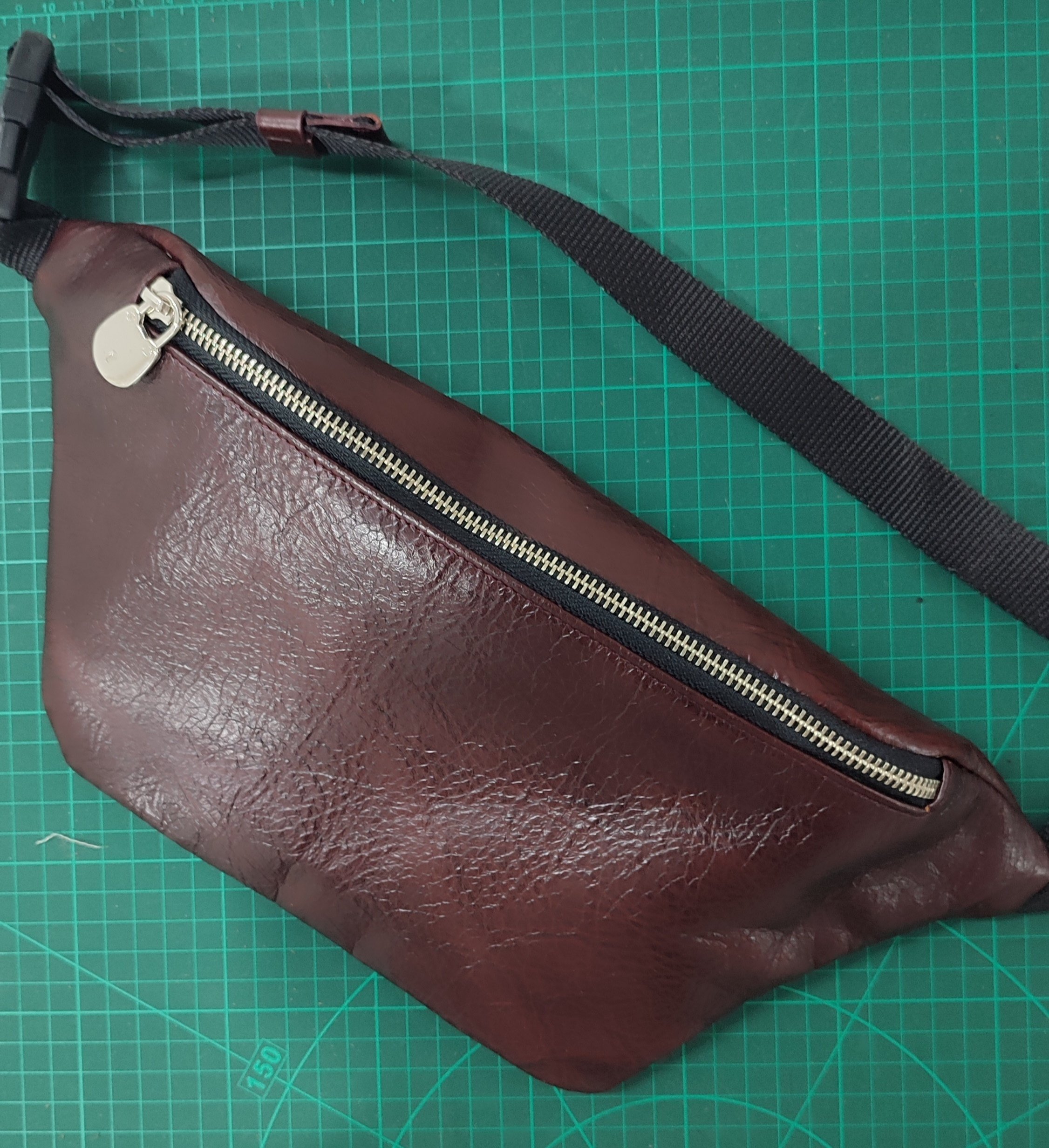 Brown leather crossbody bag crafted by a workshop participant during a Concentric Travel leathercraft workshop.