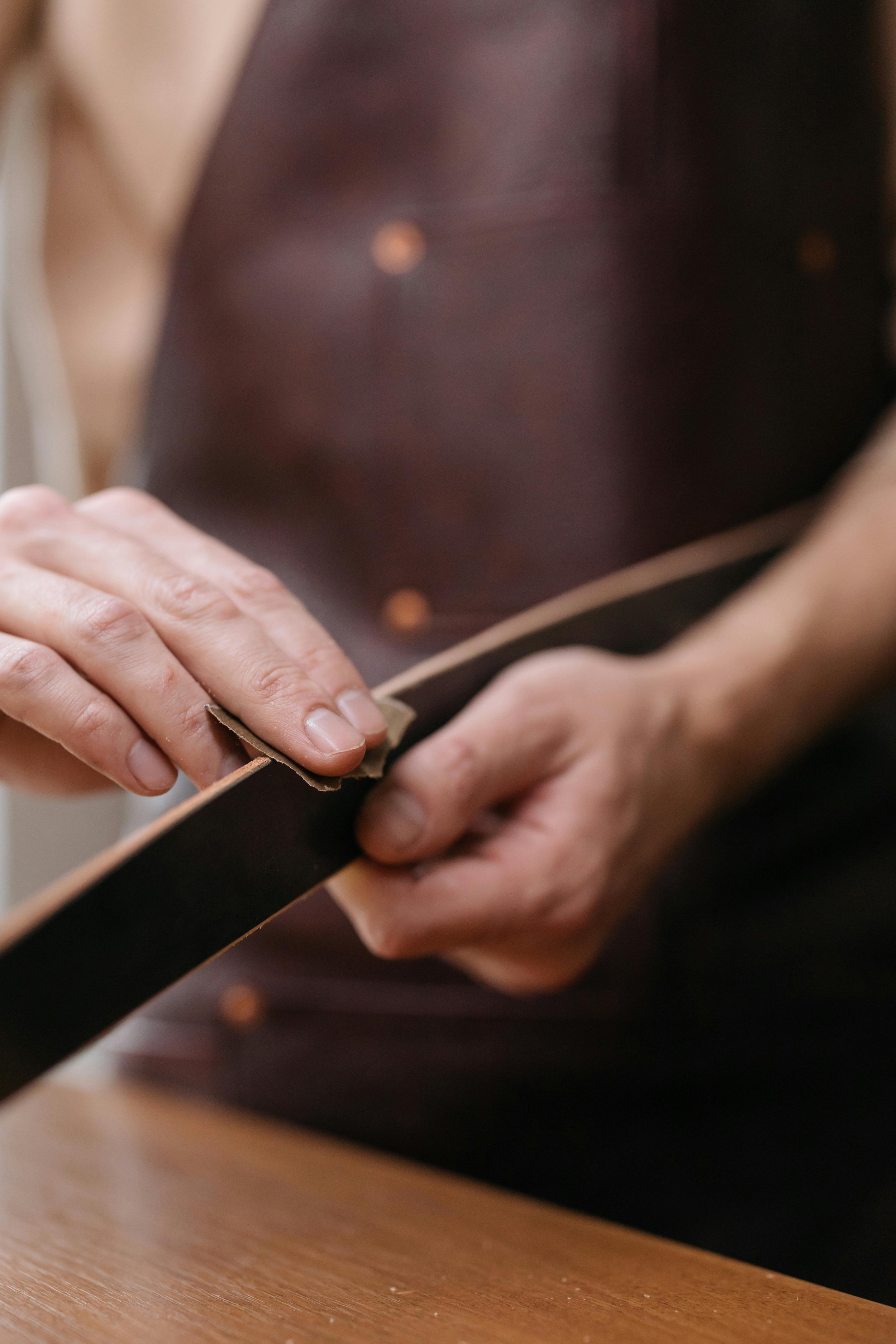 Person working on a handmade leather belt.