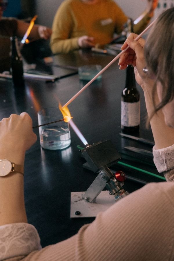 woman-using-torch-to-melt-glass-in-workshop.jpg