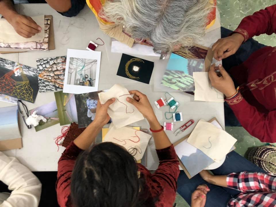 Overhead view of students working on photo embroidery projects during a workshop in Oaxaca studio