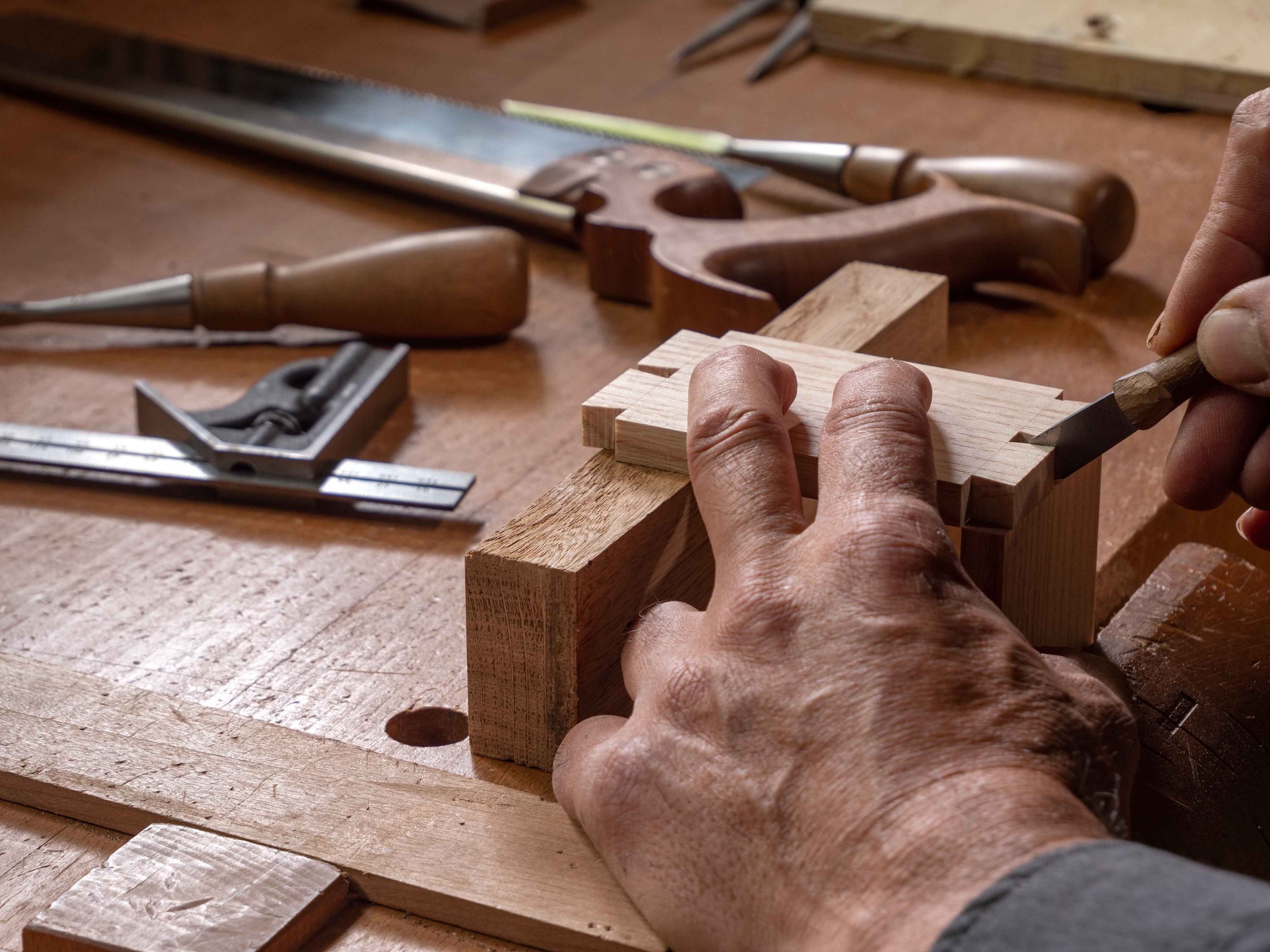 Close-up of hands shaping wood in a traditional woodworking workshop in Spain during an artisan-led workshop with Concentric Travel.