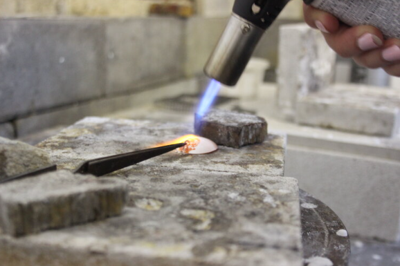 Participant using silversmithing tools to create custom silver earrings in a Bristol workshop.