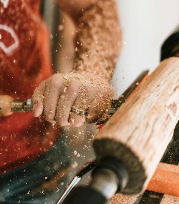 Man woodturning a piece of wood on a lathe in a hands-on workshop