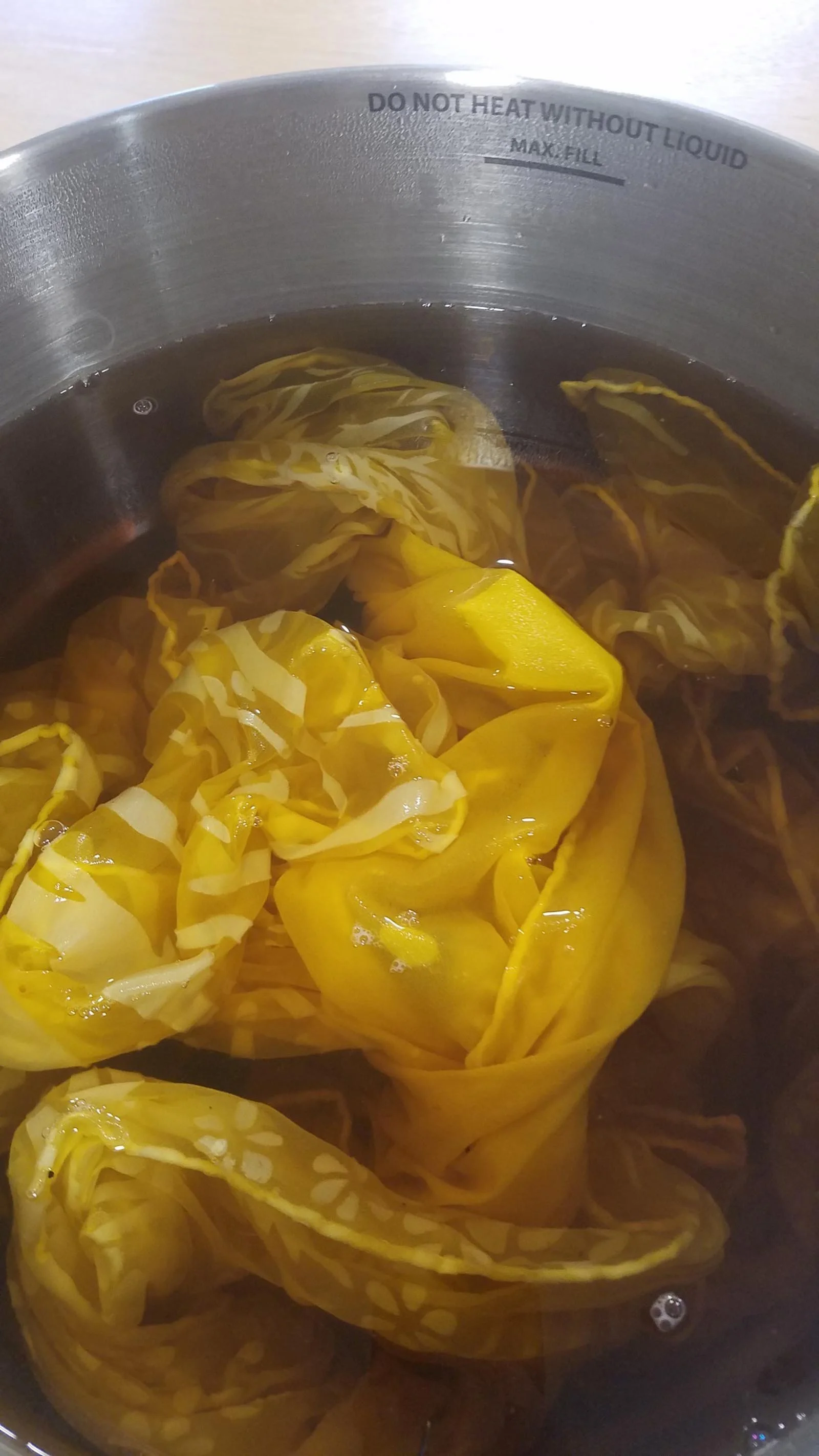 Cloth being dyed yellow in the water pot