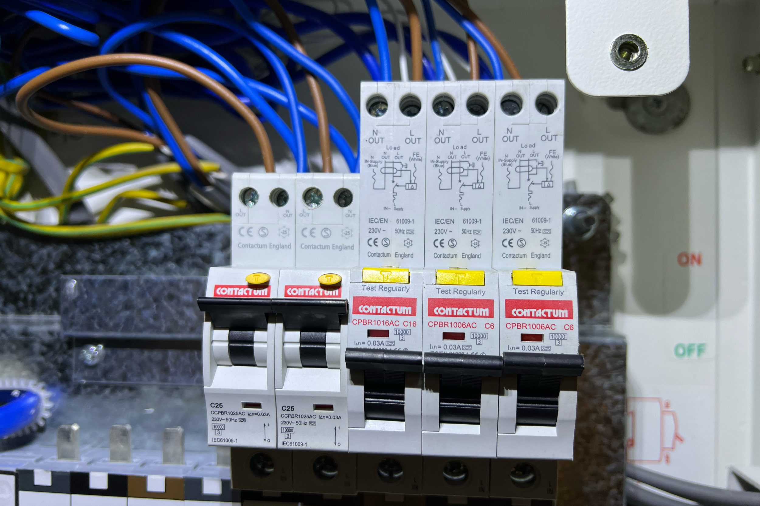 Close-up of an electrical panel with circuit breakers, wiring, and control switches.