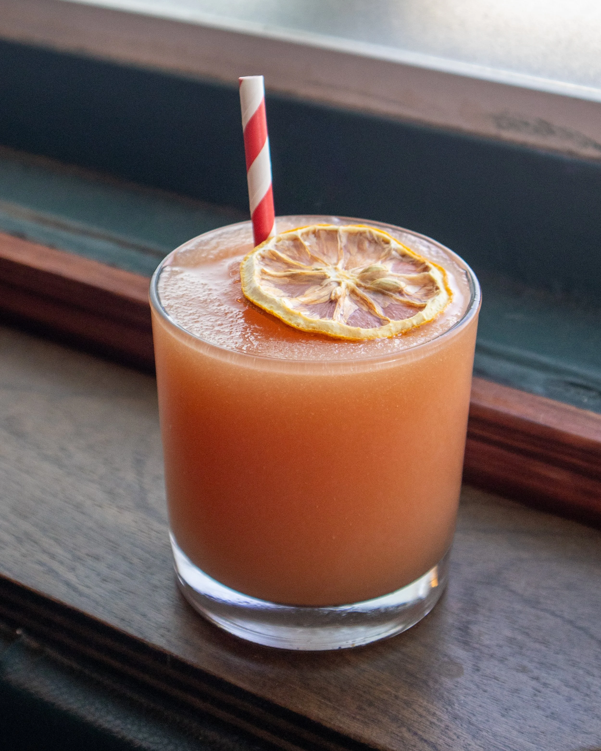 A frozen margarita cocktail with garnish and straw.