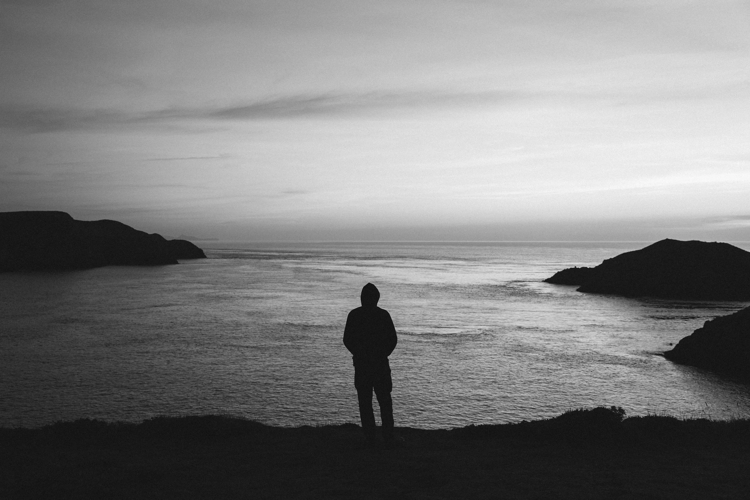Person contemplating alone by the sea.