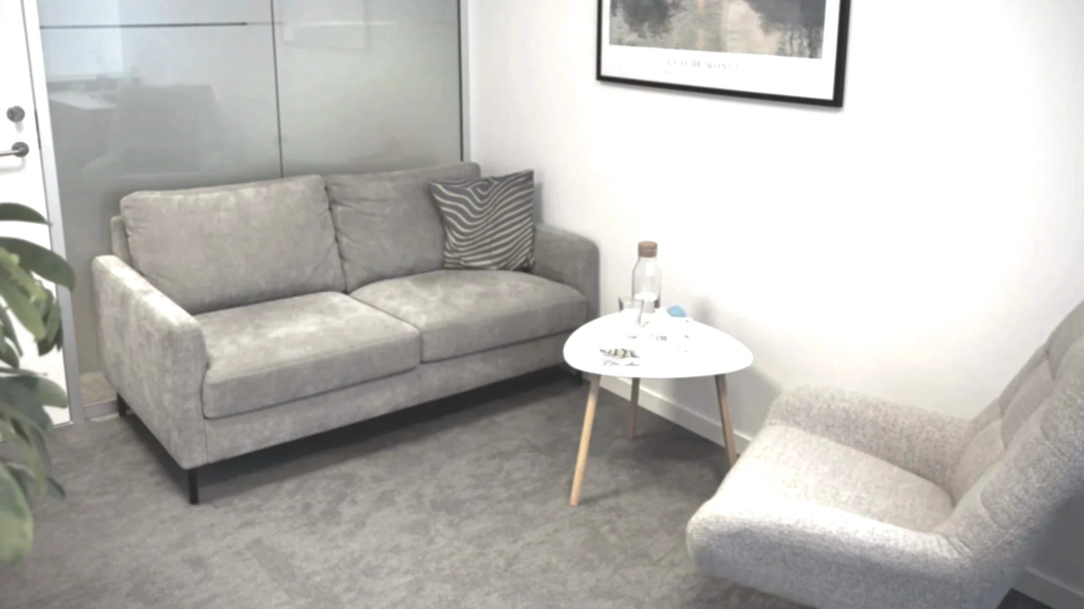 Et behagelig, moderne psykologkontor med sofa, brod og stol.