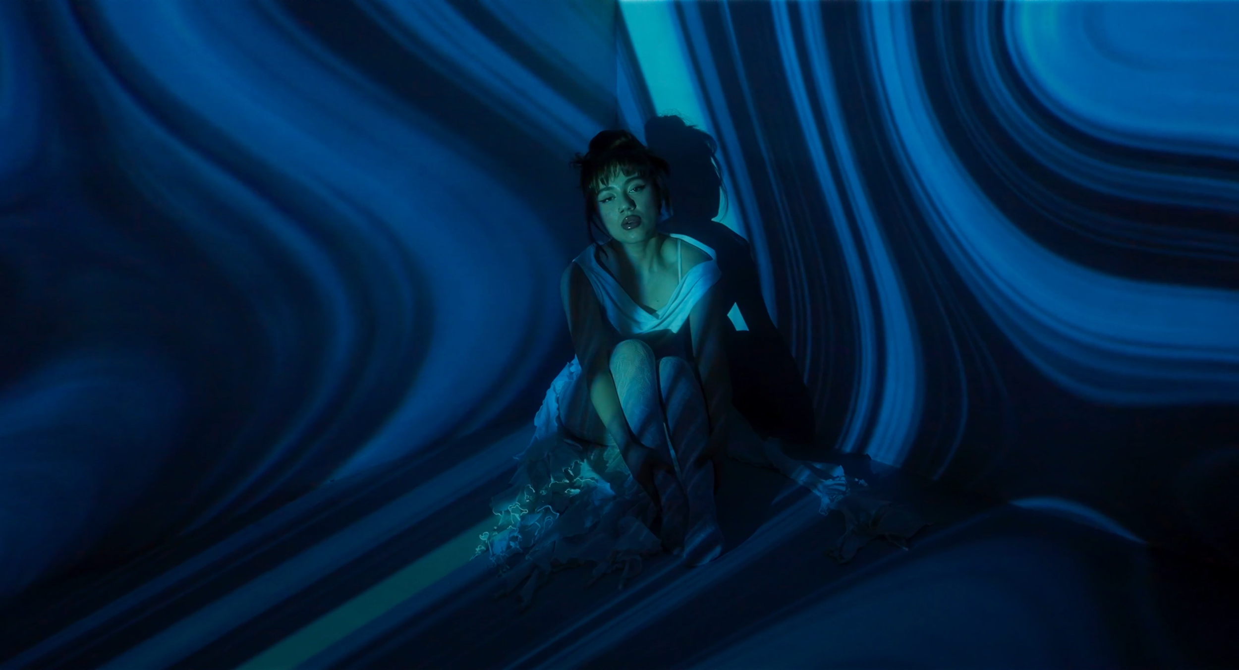 Music video still. BANA sits