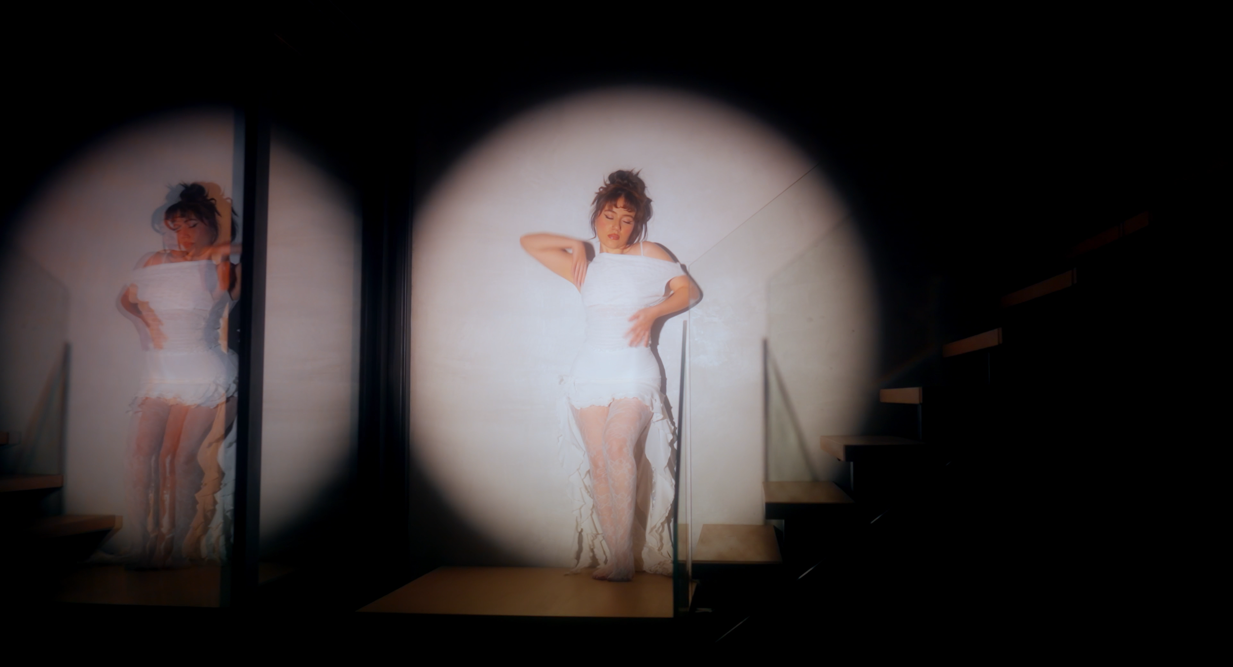 Music video still. Man lies on chair, dead.