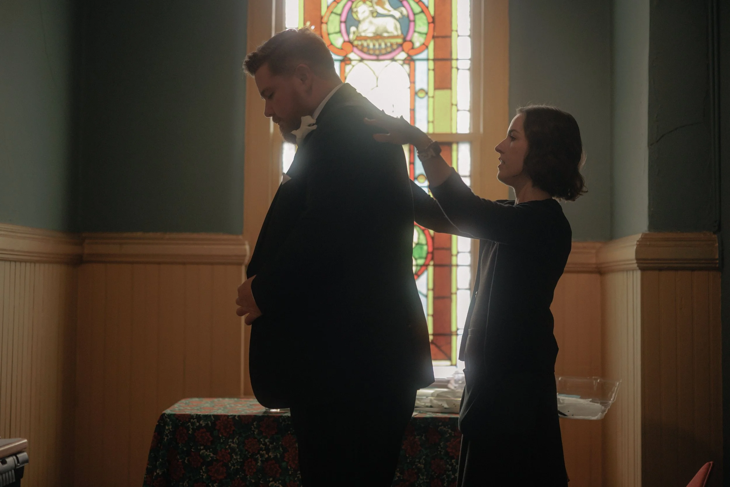 Planner brushing lint off the groom's jacket