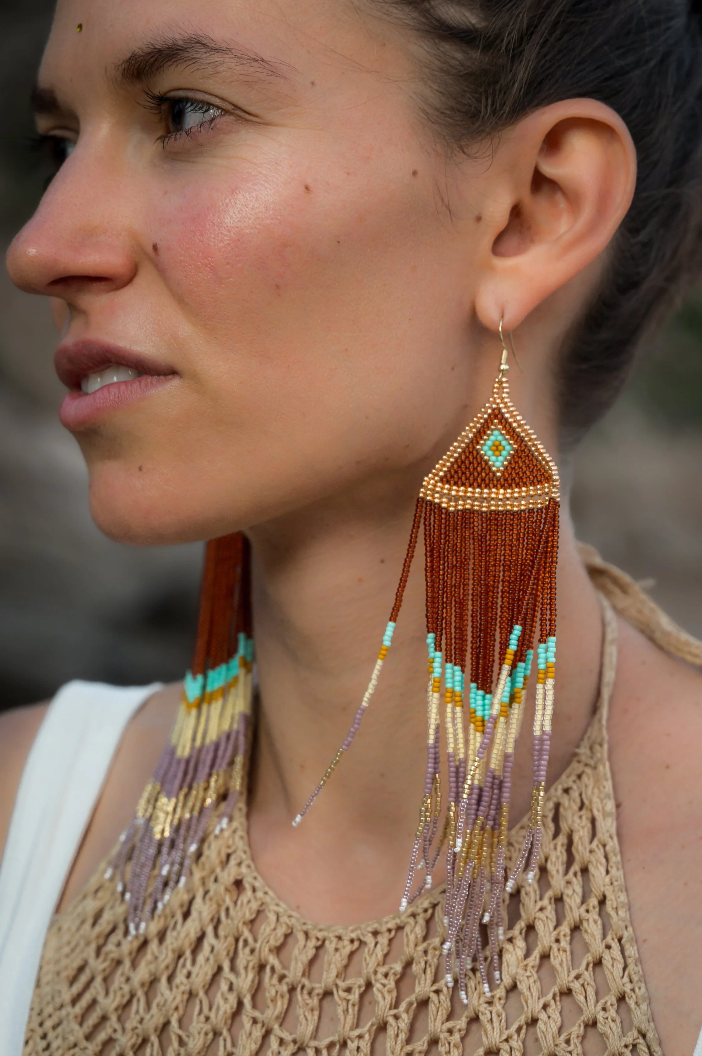 Woman wearing handmade Radiant Dakini beaded earrings, Mazunte Mexico