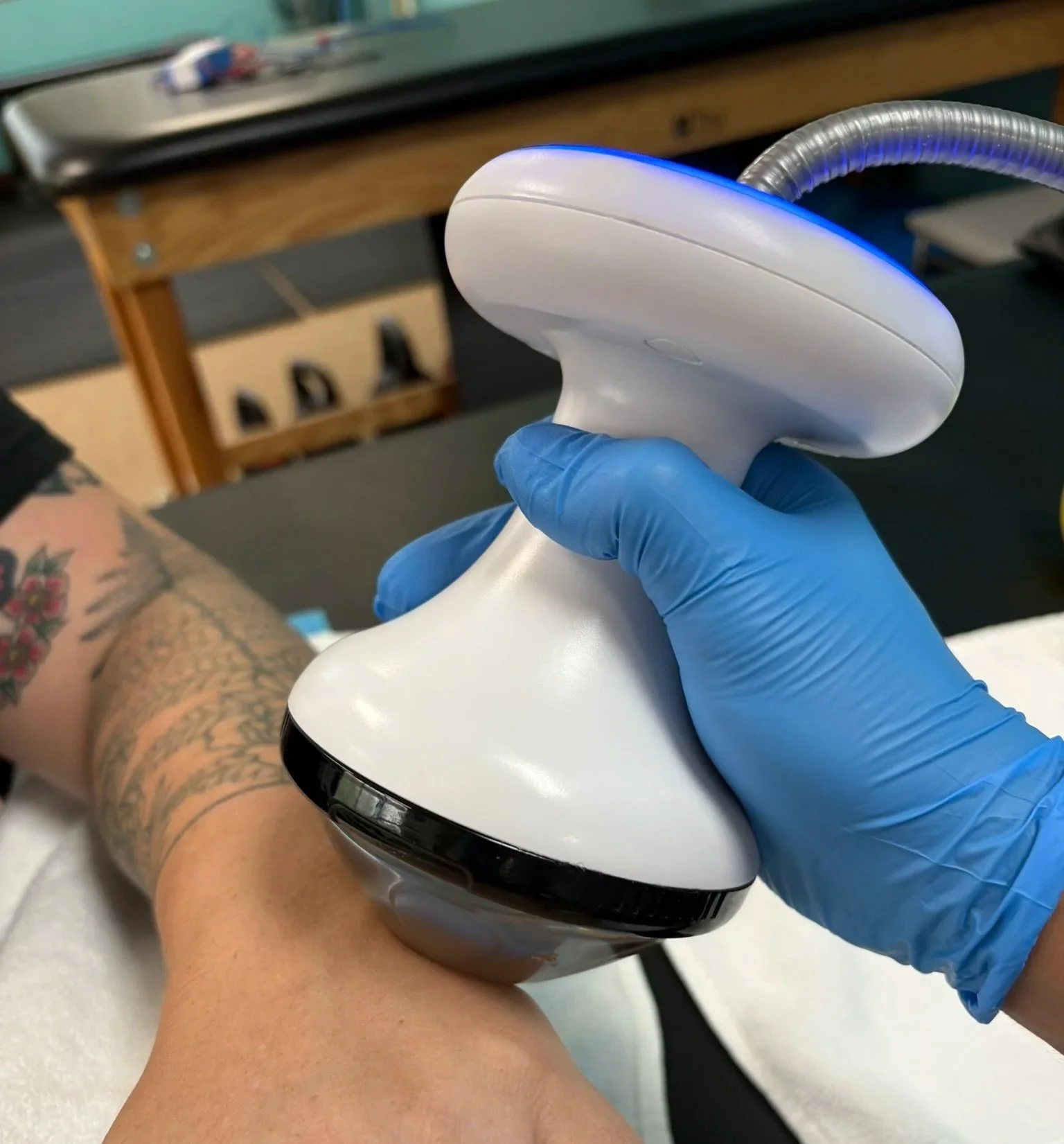 shockwave therapy being performed on the wrist of patient in physical therpy clinic setting