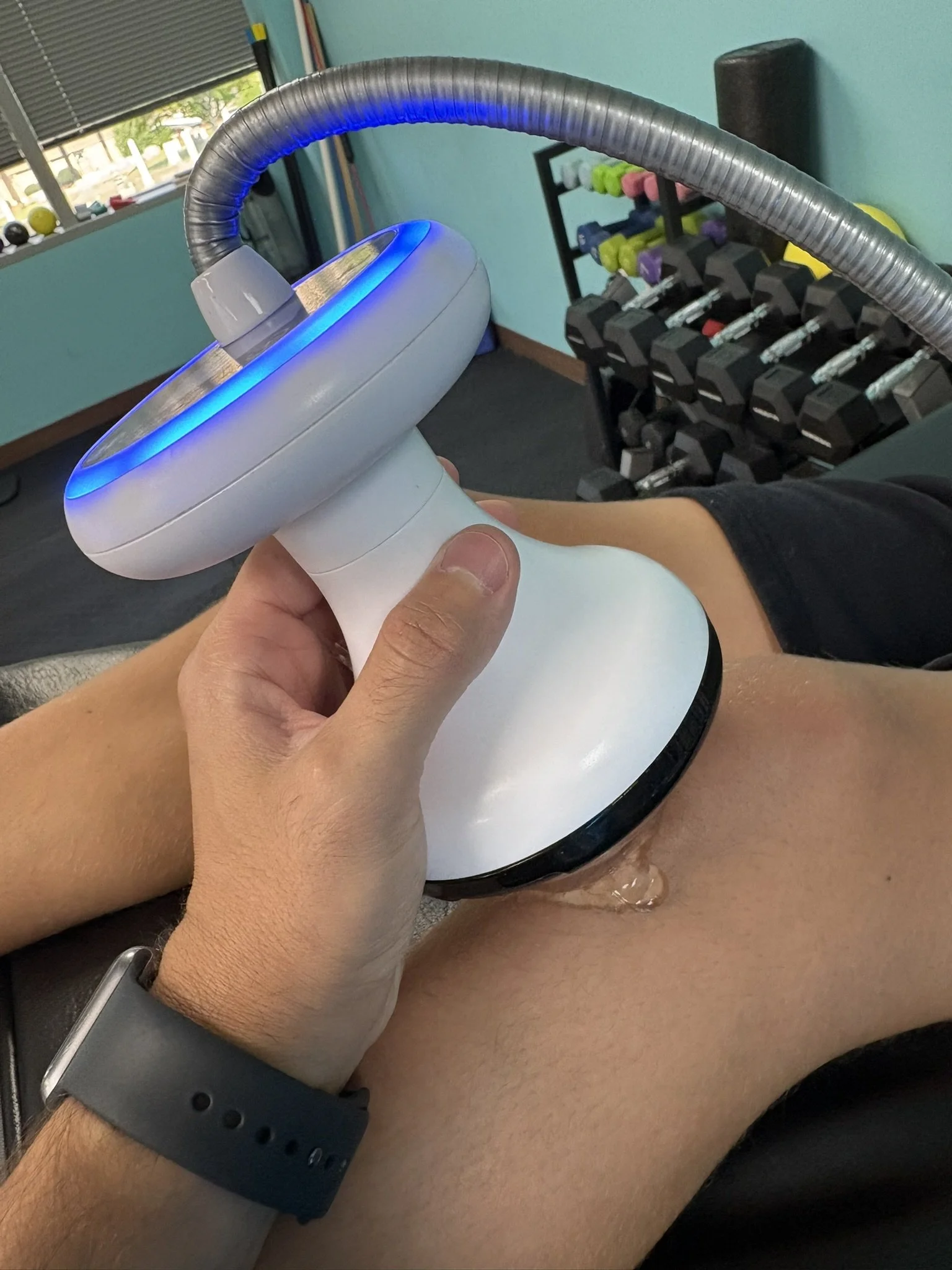 focused shockwave therapy being applied to a patients knee in a clinical setting at a physical therapy clinic