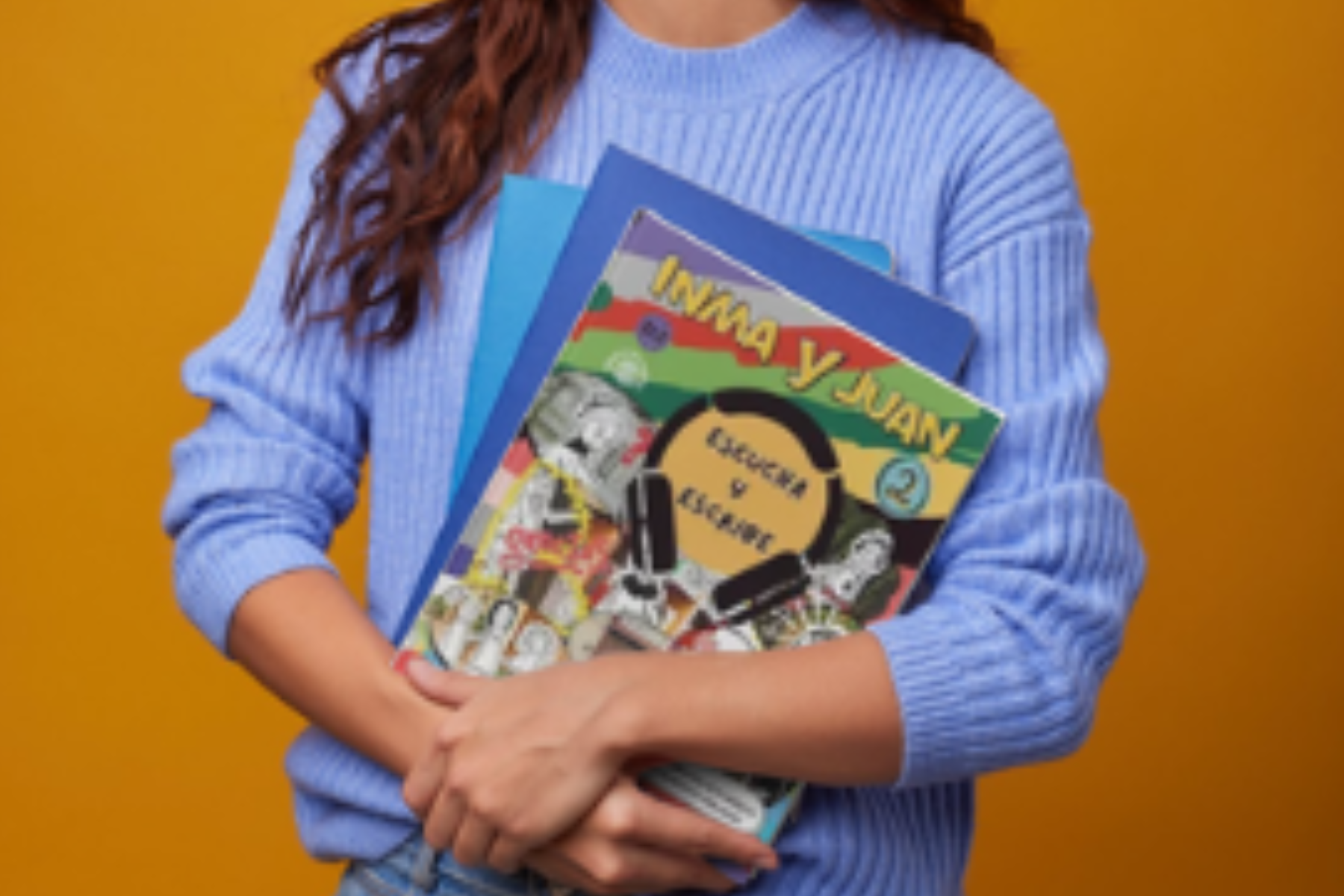Person wearing a blue striped shirt holding colorful magazines or comic books against a yellow background.