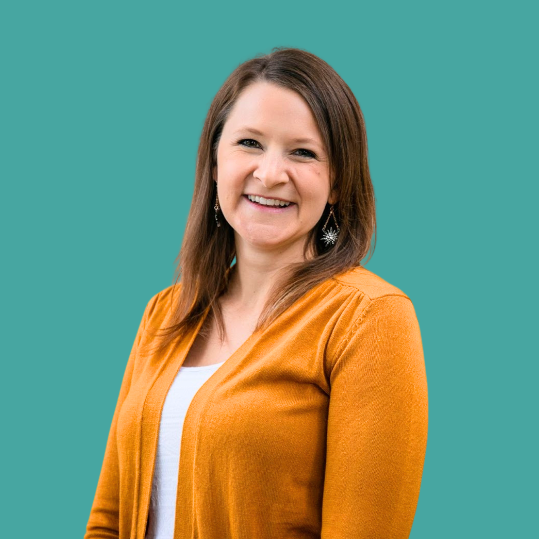 Smiling headshot of woman with orange cardigan against teal background