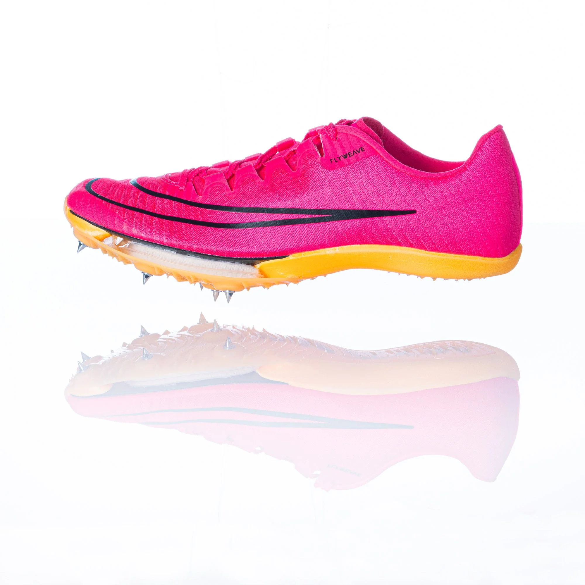 A bright pink running shoe with black accents and yellow sole, featuring cleats on the bottom for traction.