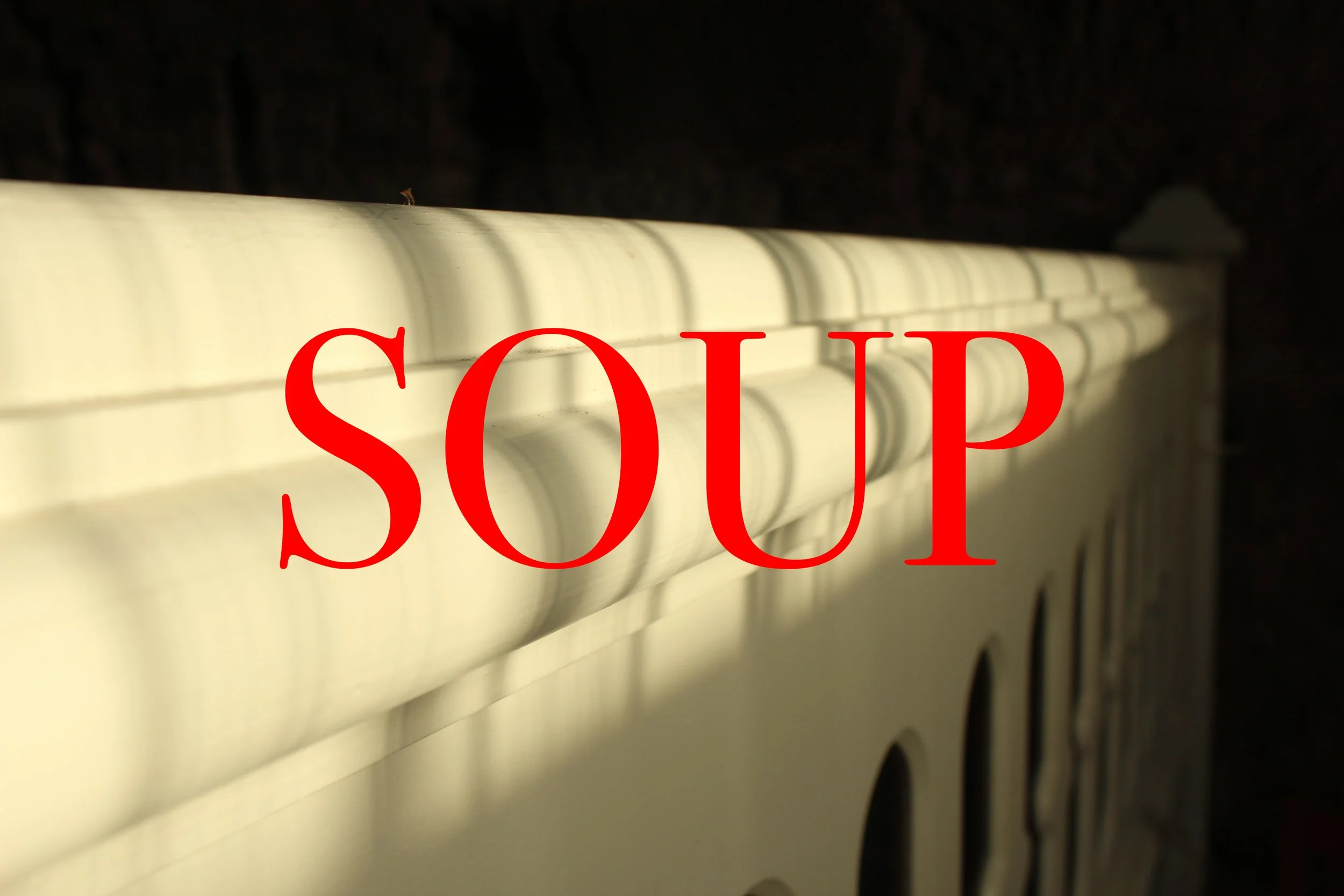 Close-up of a white house gutter with shadows, overlaid by the red word 'SOUP' in the center.
