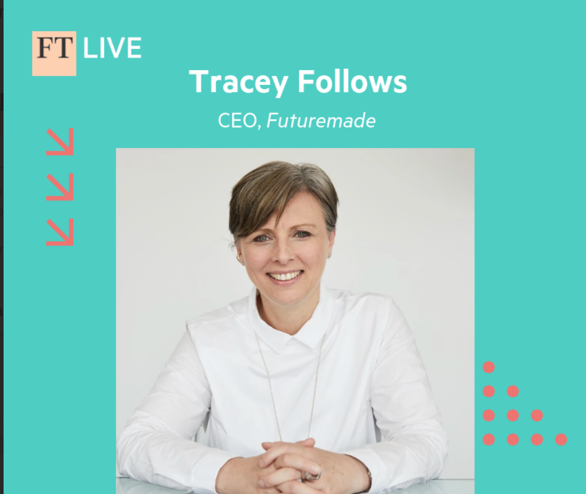 A woman with short brown hair smiling and sitting at a table in a white shirt, photographed for a live interview promoting Tracey Follows closing keynote at FTTech Live.