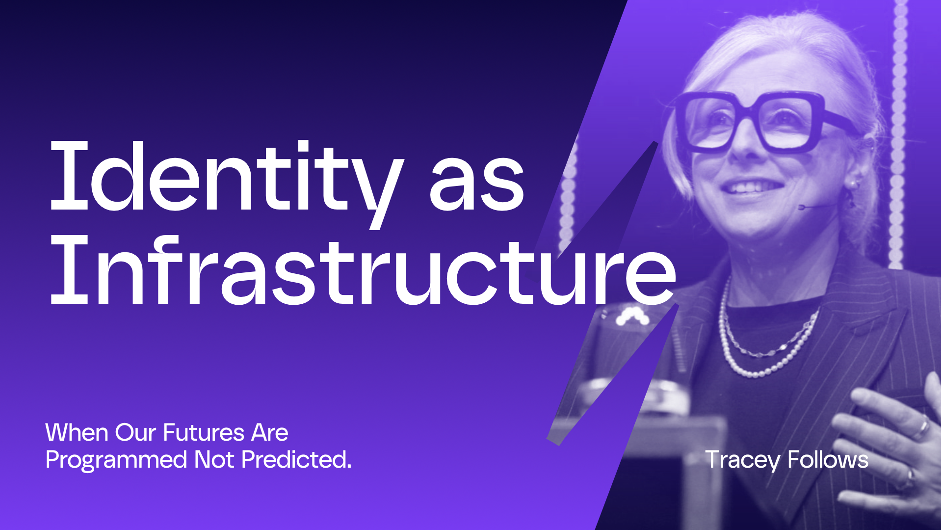 A woman wearing glasses speaking at a conference with the title 'Identity as Infrastructure' and the subtitle 'When Our Futures Are Programmed Not Predicted.'