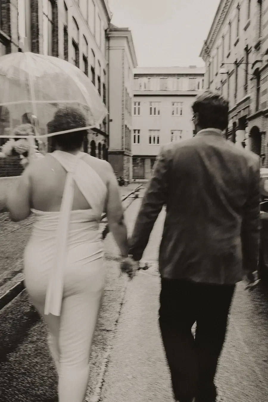 Svartvit bild av brudpar i rörelse genom staden på väg till sin vigsel i rådhuset i Göteborg.