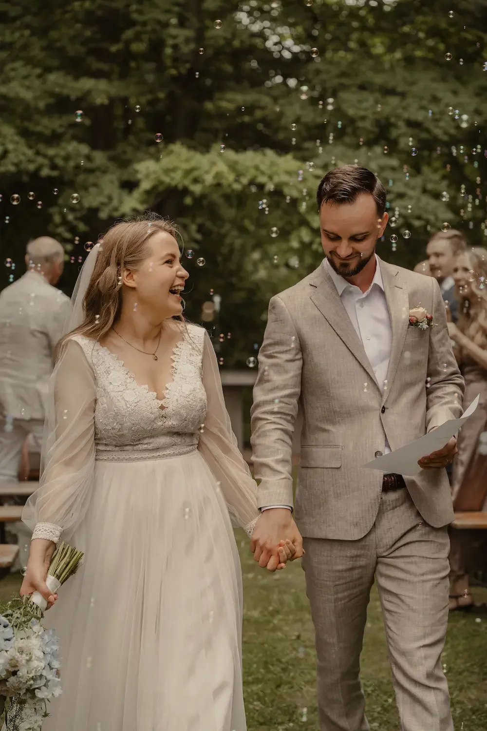 Glatt brudpar som marscherar ut från sin vigsel i utomhusmiljö.