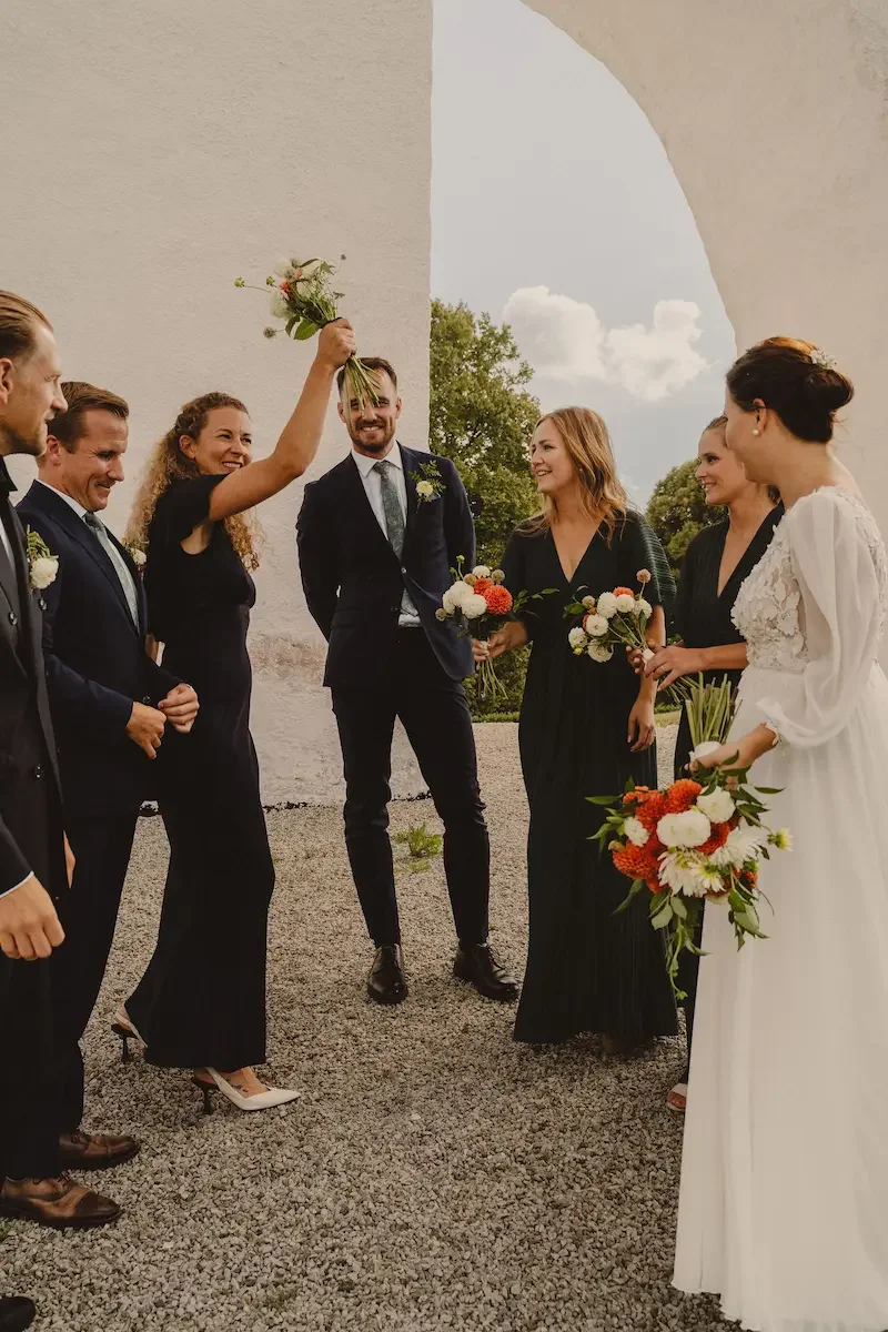 Brudföljet firar tillsammans efter brudparets vigsel utanför Vitaby kyrka på Österlen.