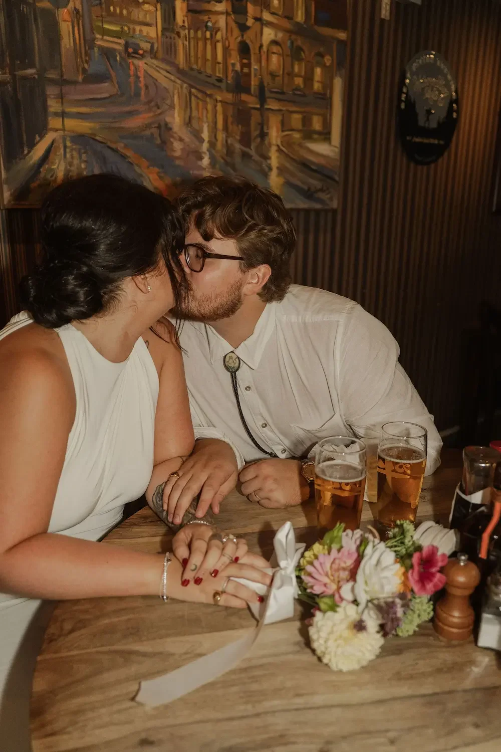 Nyblivet brudpar som firar sin rådhusvigsel med öl på Ölrepubliken i Göteborg. Bilden har murrig pubmiljö och direct flash för en cool, editorial känsla.