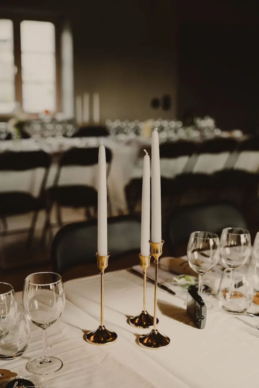 Närbild på dukning och ljus i väntan på att bröllopsmiddagen ska starta på Mellby Atelier i Skåne.