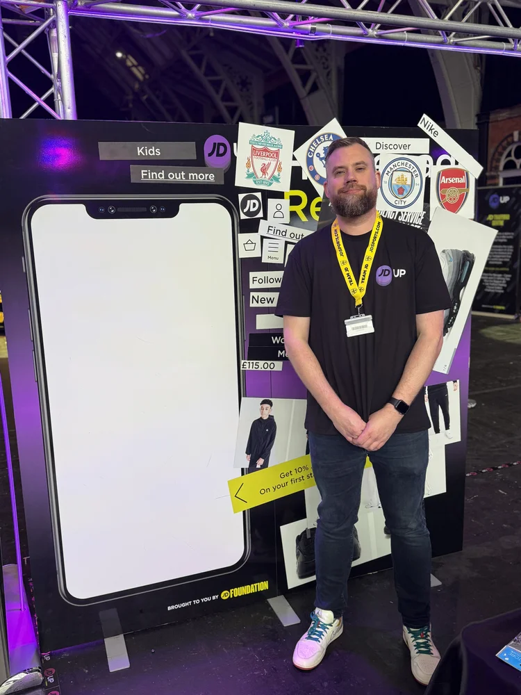 Richard Ilott at JD UP 2026 in Manchester, JD Sports’ foundation event for young people from the local community, in front of a large display showing the JD Sports app navigation
