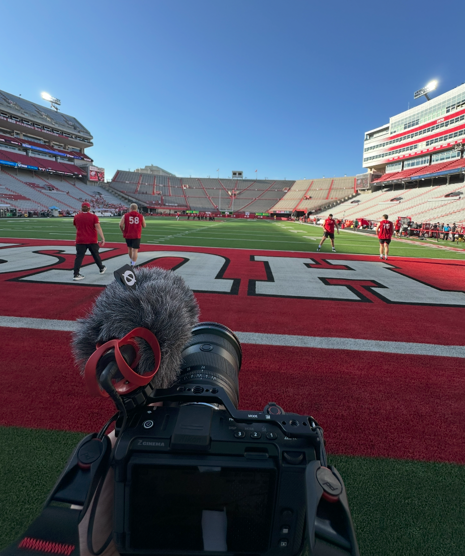 Camera and microphone recording football pregame warmups from the field.