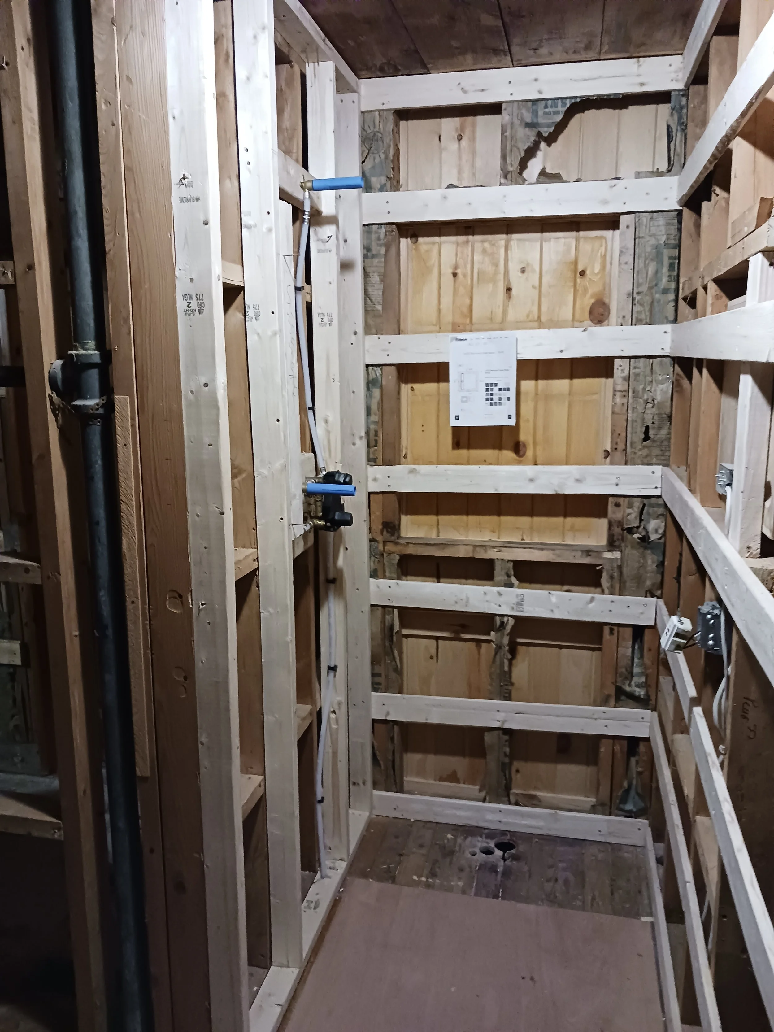 Construction site with wooden framing and scaffolding in progress.