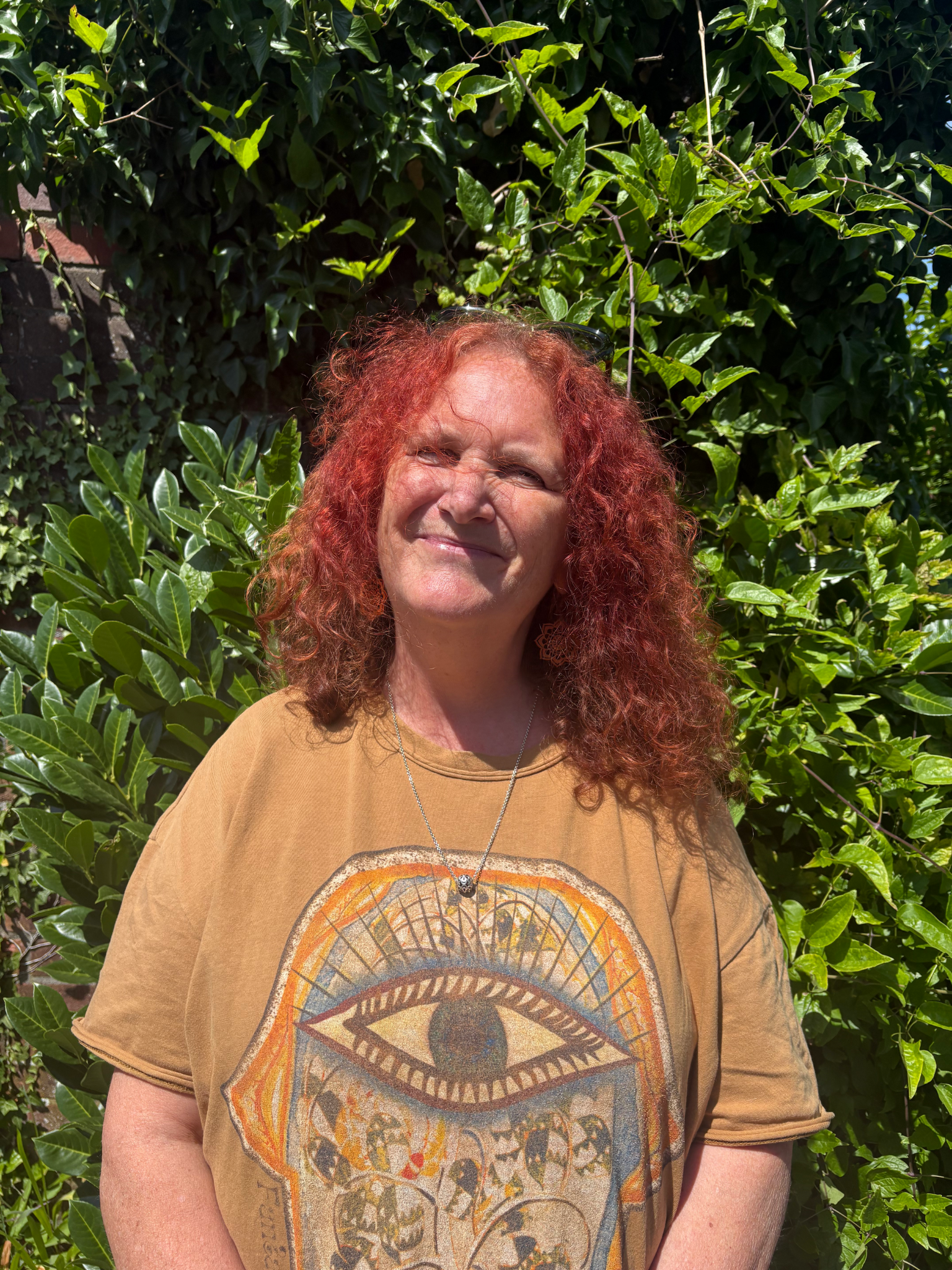 Headshot of Manda who has fiery red curly hair and a warm smile