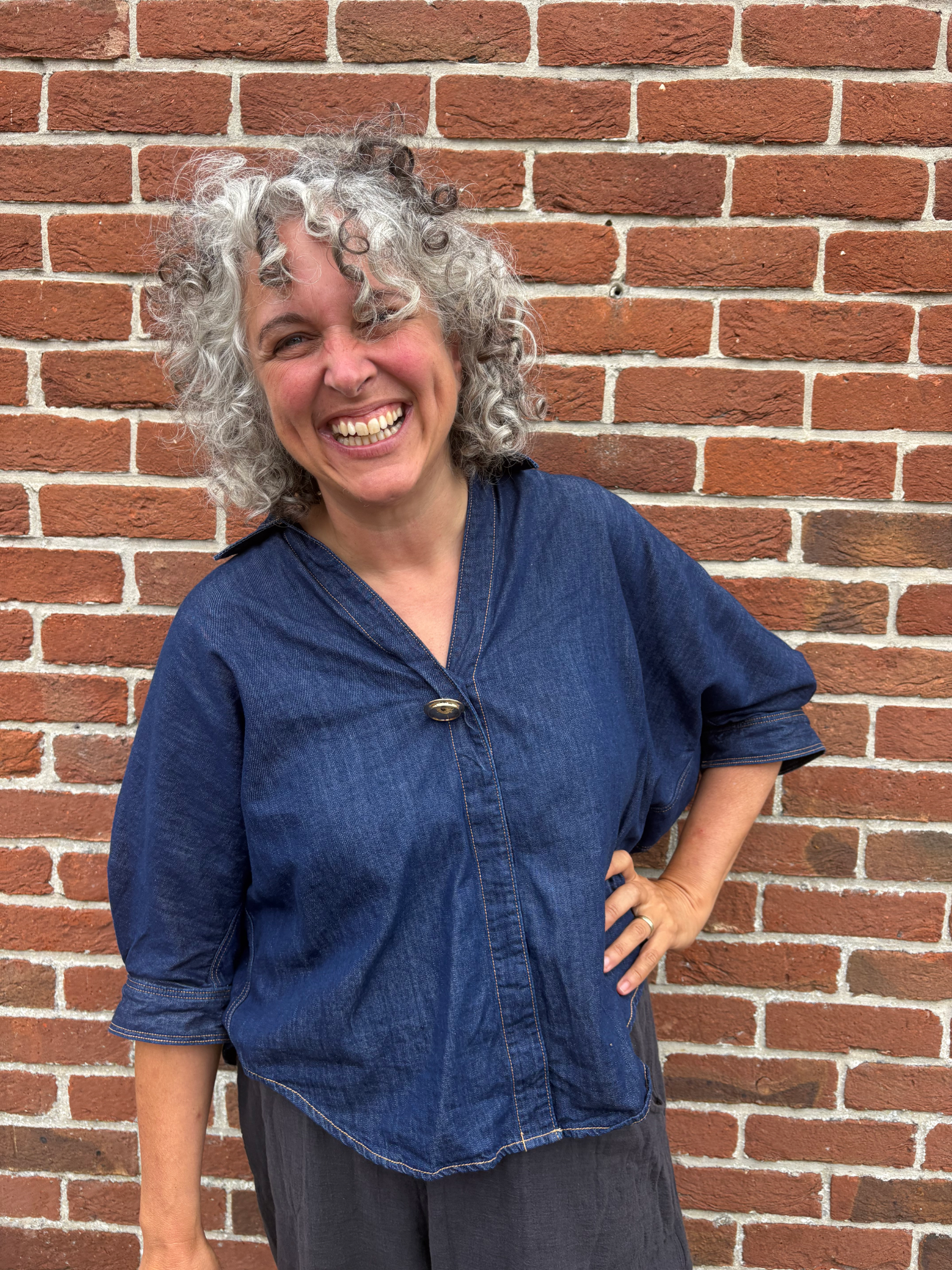 headshot of Mary, a smiling woman with curly brown hair.