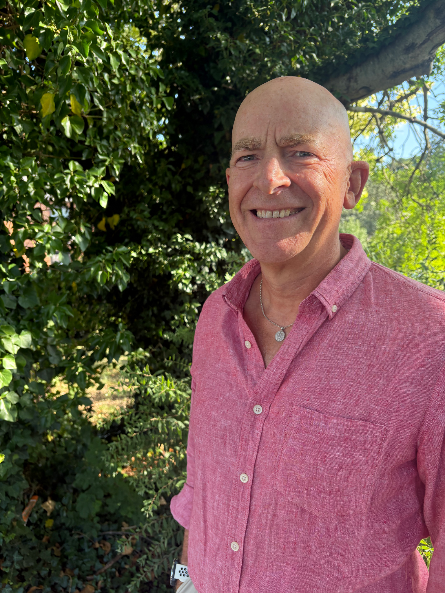 Headshot of Neal, a gentleman with no hair, smiling at the camera.