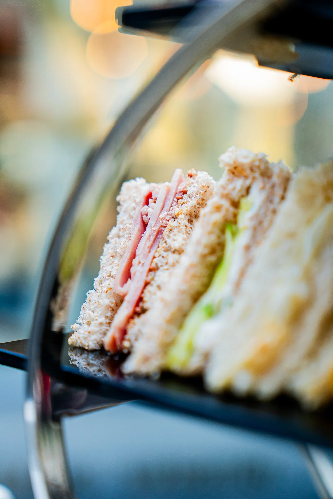 Close-up of freshly prepared finger sandwiches, including ham and mustard, egg mayo, Tuna and cucumber on a luxury afternoon tea tier at The Fizzy Tarté.