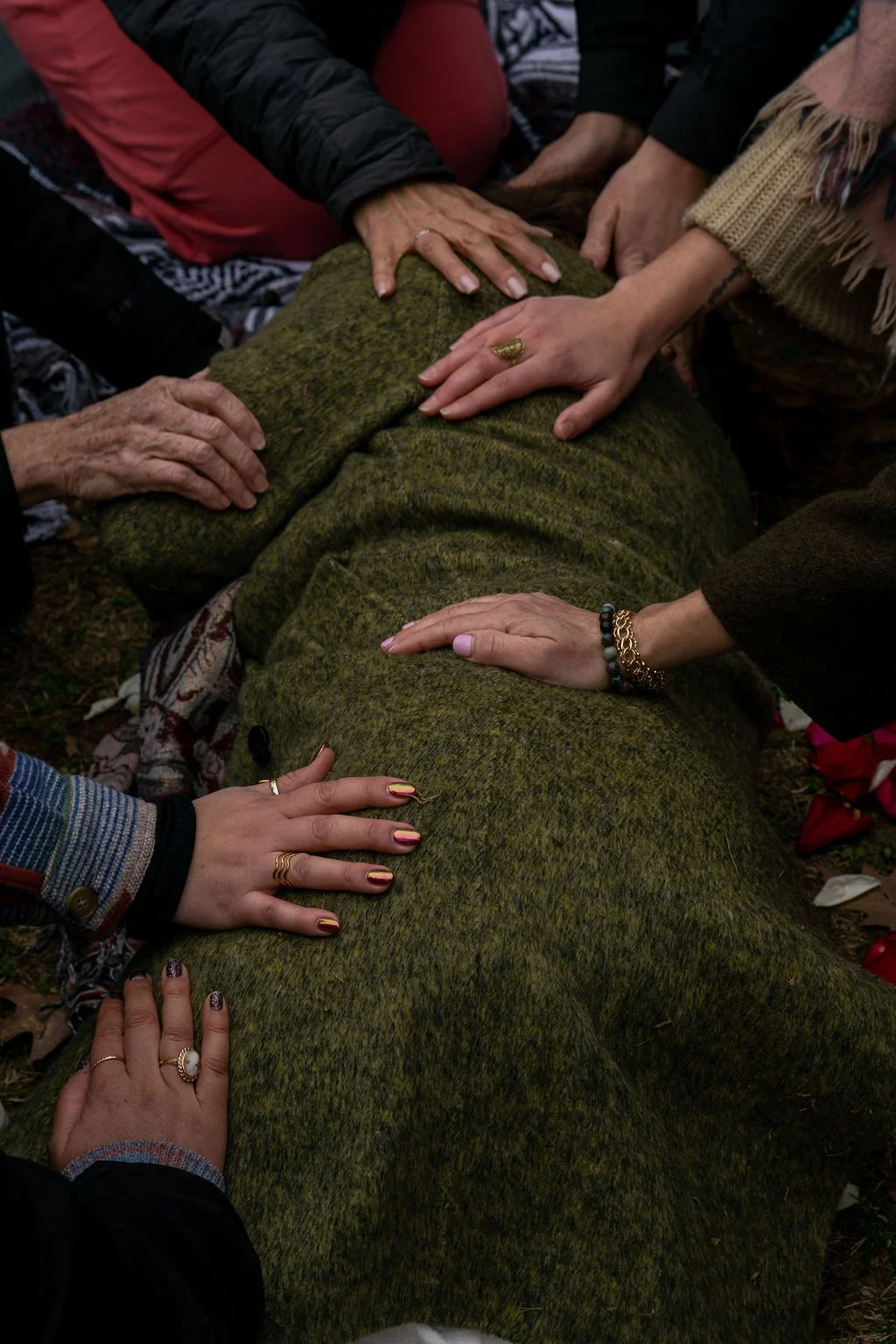 women laying hands praying over a woman as she is reborn